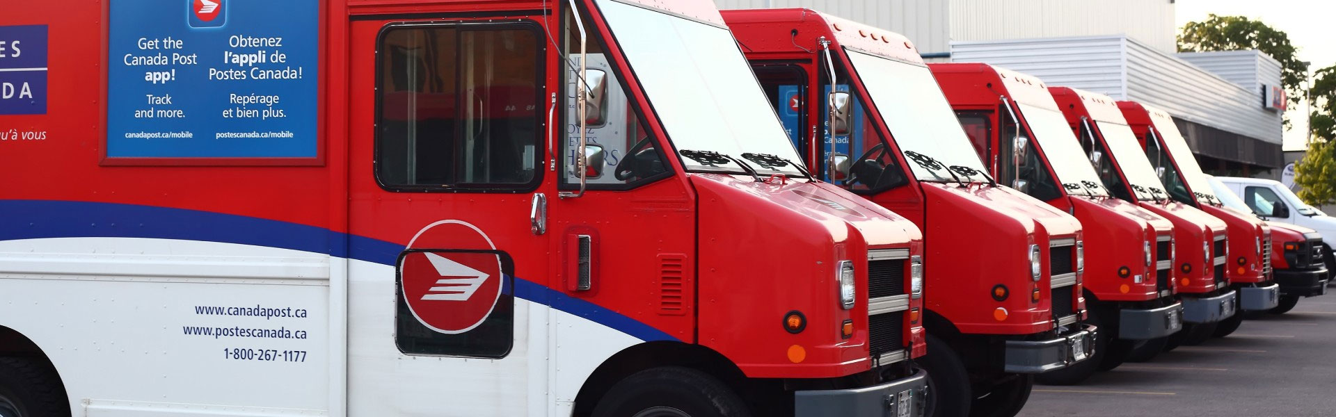 Three Canada Post vehicles parks in a loading dock.